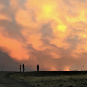 Orange clouds with three humans on horizon